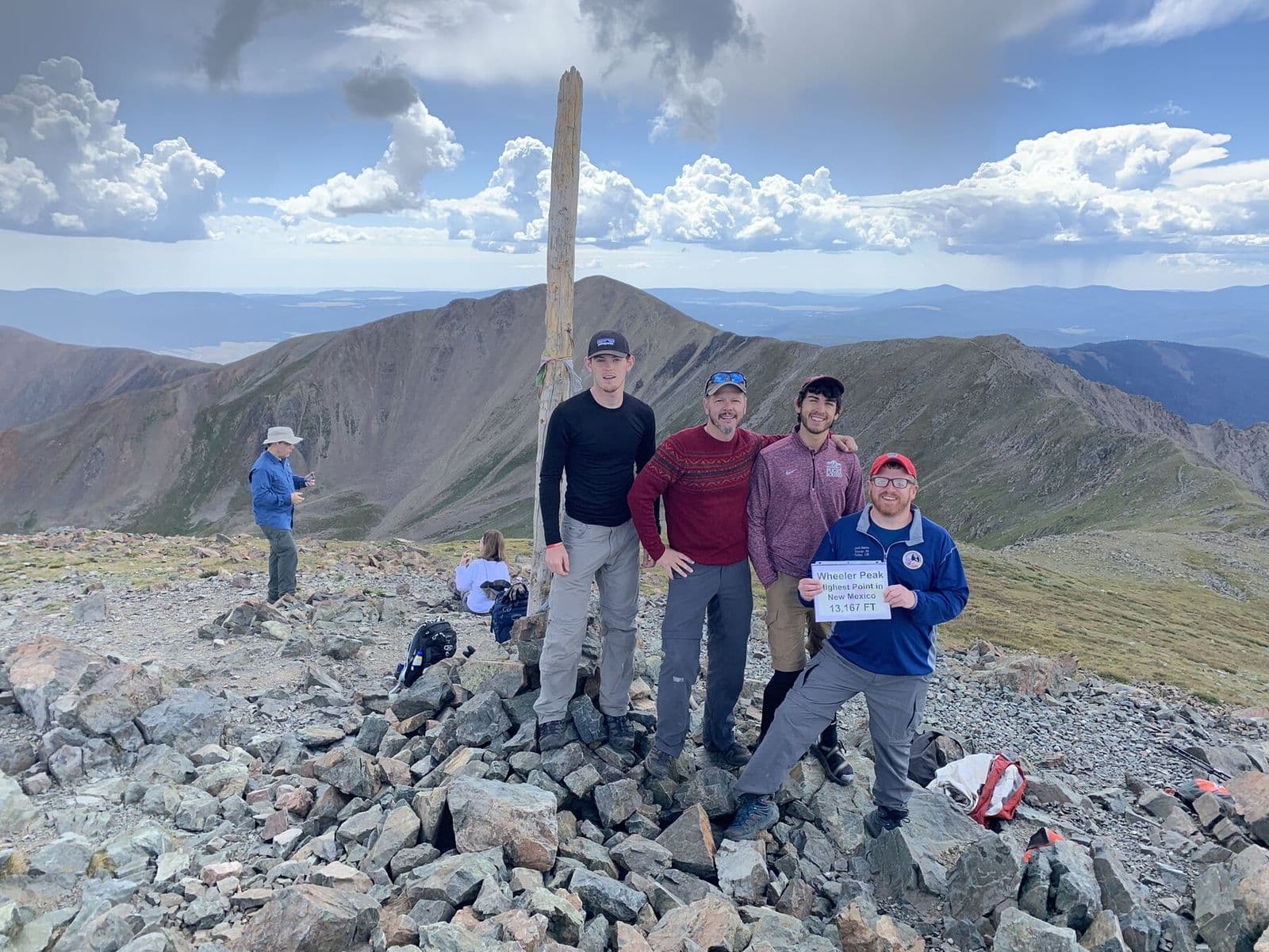 Backpacking crew gathered on a high mountain summit