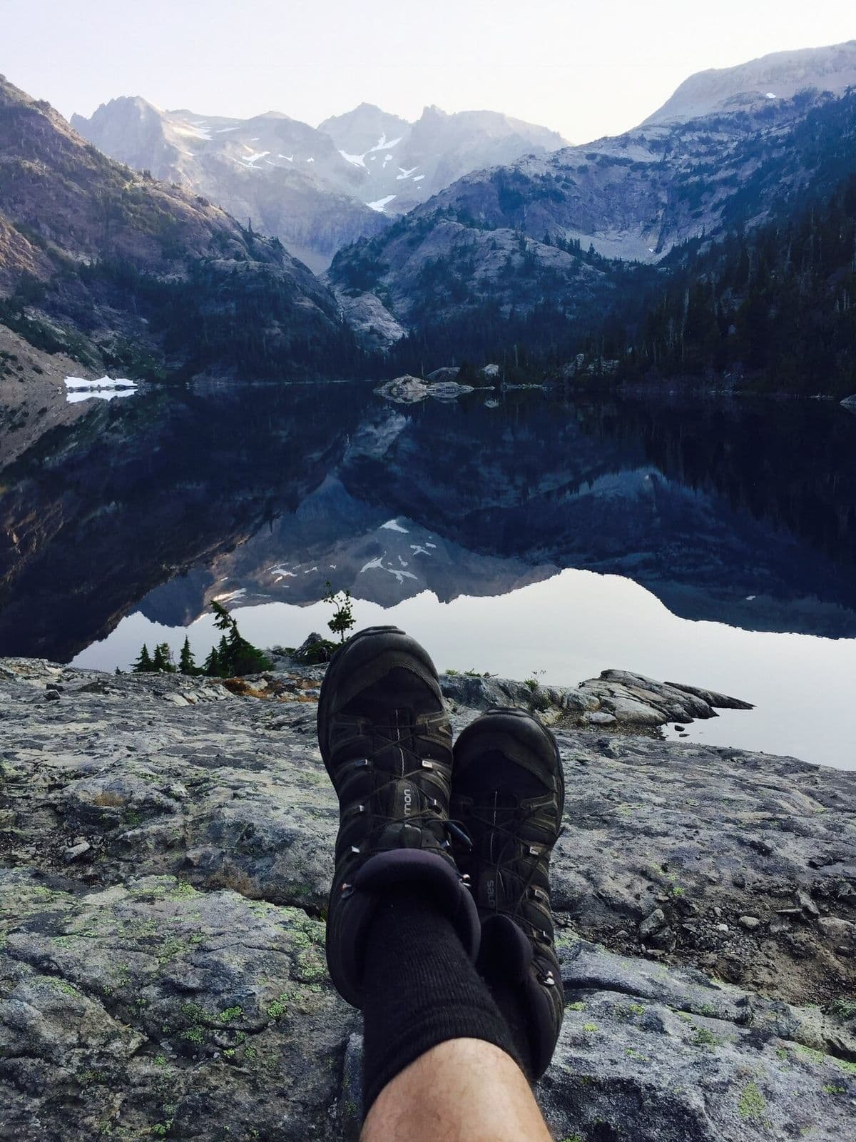 Hiker looking across a remote alpine lake in the Cascades
